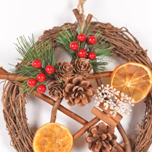 Christmas pentagram wreath detail, featuring natural pinecones, dried orange slices and berries.