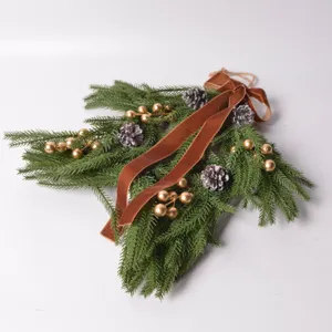 Christmas decorative pine swag with velvet bow and golden berries for holiday wall hanging.