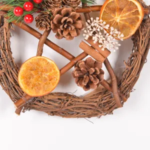 Close-up detail of rustic Christmas wreath featuring pine cones, dried orange slices and berries.