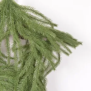 Artificial Christmas pine needle branch detail, green foliage for festive home decoration.
