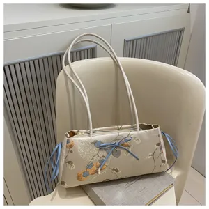 Detail view of Chinese style satin shoulder bag with blue ribbon bow and delicate fruit print.