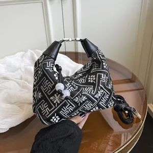 Chic Chinese style embroidered shoulder bag with unique geometric pattern and chic tassels.