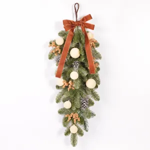 Artificial Christmas teardrop swag with velvet bow and flocked pinecones for holiday decor.