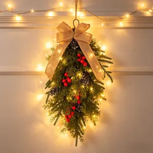 Detailansicht des Weihnachtstropfen-Kranzes mit Tannenzapfen, Beeren und warmen Lichtern.