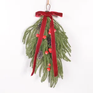 Détail de la guirlande de Noël en forme de larme avec nœud en velours et pomme de pin.