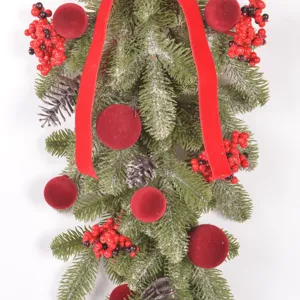 Close-up detail of artificial Christmas teardrop swag with pinecones and red berries.