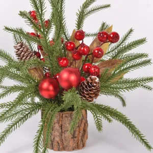 Mini kunstkerstboom met dennennaalden, rode bessen en dennenappels in een schorspot.