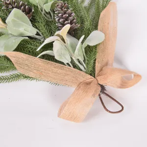 Close-up detail of artificial Norfolk pine needle teardrop swag with frosted leaves and pinecones.