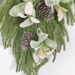 Detail of artificial Christmas Norfolk pine needle, flocked lamb leaf and pine cone holiday swag.