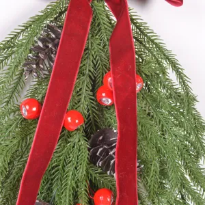 Vue rapprochée de guirlande de Noël artificielle en forme de larme avec ruban de velours.
