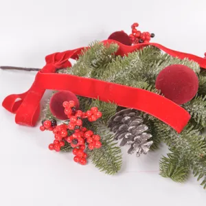 Close-up detail of artificial Christmas teardrop swag with pine needles, red velvet ribbon and berries.