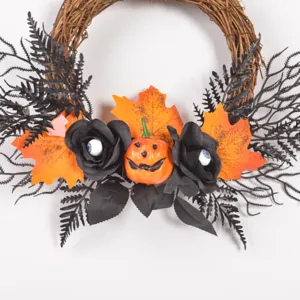 Halloween wreath detail showing black roses, spooky eyeballs, artificial maple leaves and pumpkin.