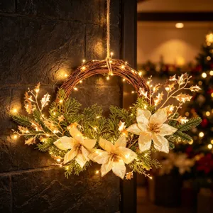 Ghirlanda artificiale luminosa di Natale con poinsettia dorate e rami per parete.