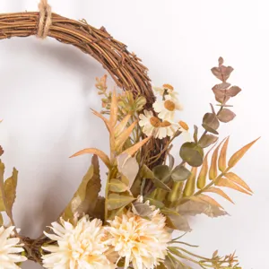 Close-up detail of autumn artificial flower wreath with daisy and eucalyptus leaves for decor.