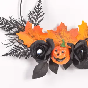 Halloween Deko-Kranz Detail mit gruseligen schwarzen Rosen und niedlichem Kürbis.