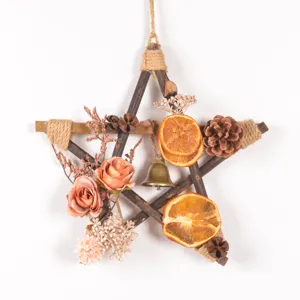 Rustic wooden star Christmas hanging ornament with dried orange slices and pine cones for home.