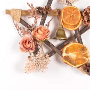 Rustic wooden star wreath detail showing dried orange slices and pine cones for holiday decor.