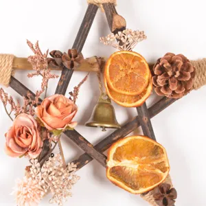 Vintage wooden star Christmas wreath pendant with dried orange slices, pine cones and bell