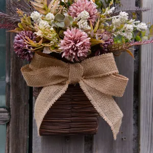 Artificial flower wall hanging detail, wicker basket with burlap bow and pink floral decor.