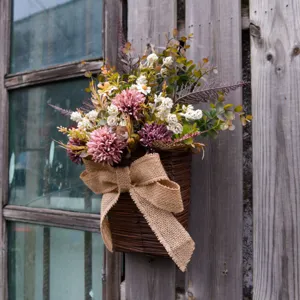 Artificial flower hanging basket detail, rustic wall decor bouquet with burlap bow.
