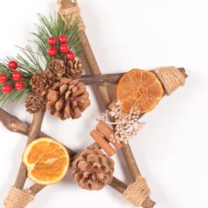 Rustic wooden star Christmas wreath detail, natural pinecones and dried orange slices.