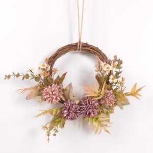 Artificial autumn flower wreath detail view with vintage fake chrysanthemums and twine hanging.