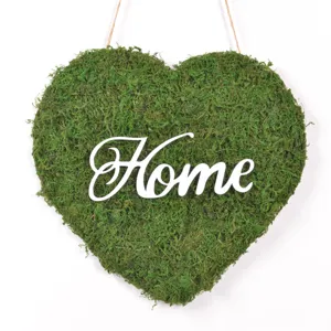 Primo piano del cartello in muschio a forma di cuore con Home, dettaglio foresta.