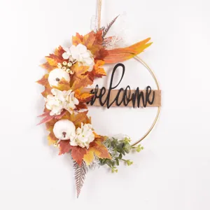 Autumn iron wreath wall hanging featuring artificial maple leaves, white pumpkins and welcome sign.