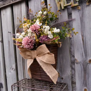 Artificial hanging flower basket with pink mums and burlap bow for home garden decor.