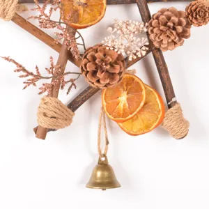 Rustic wooden star Christmas wreath detail with pine cones and dried orange slices for holiday decor.