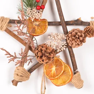Rustic wooden star Christmas wreath with pine cones and dried orange slices for decor