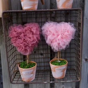 Detail view of heart-shaped mesh topiary potted plants, perfect for Valentine's Day decor.