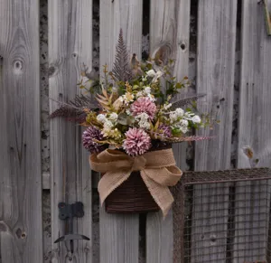 Detailed view of artificial wall hanging flower basket with rustic burlap bow for home decor.