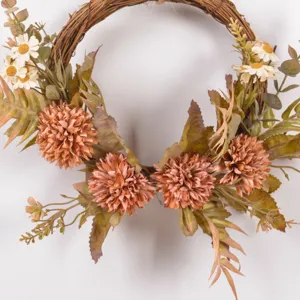 Closeup detail of autumn artificial flower wreath with rustic twigs, daisies, and faux leaves.