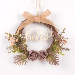 Detailed view of artificial autumn floral wreath with wooden hello sign and burlap bow.