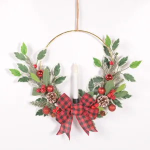 Couronne de bougie de Noël avec nœud écossais pommes pin baies rouges et feuilles vertes artificielles.