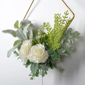 Close-up of Nordic artificial flower wall hanging with white roses and gold iron frame.