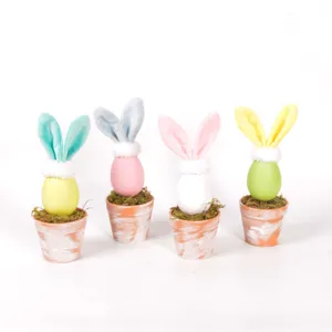 Detail shot of Easter egg bunny potted ornament with colorful plush ears and moss in mini pots.