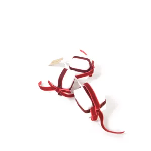 Close-up detail of red velvet ribbon gift box Christmas tree pick and holiday decor.