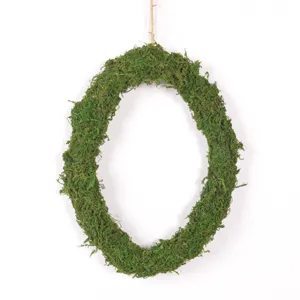 Close-up detail of green moss oval wreath, natural spring hanging decor for home wall.