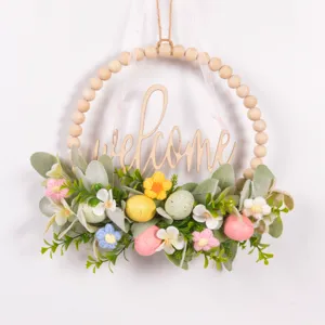 Easter wooden bead wreath detail featuring artificial lamb ear leaves and colorful speckled eggs.