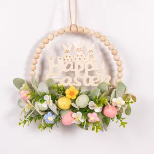 Easter wooden bead wreath detail view featuring cute bunny sign, green leaves and pastel eggs.