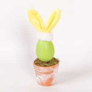 Close-up detail of Easter bunny egg potted plant ornament with cute plush ears and moss.