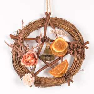 Rustic vine pentagram Christmas mini wreath with dried fruit slices, pinecones, and bell.