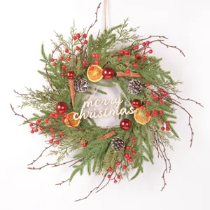 Detailed shot of Christmas wreath with pine needles, berries, and wooden merry christmas sign.