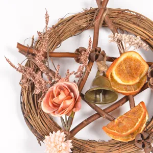 Mini Christmas twig wreath with dried orange slices, pinecones, bell and artificial flowers.