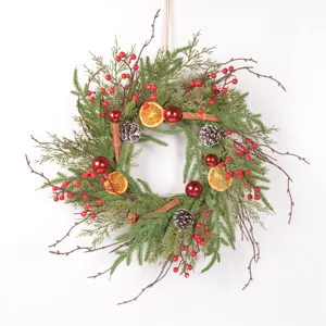 Rustic Christmas wreath with pine needles, dried orange slices and pinecones for holiday decor.