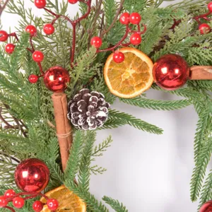 Christmas wreath detail shot featuring pine needles, dried orange slices, and pine cones.