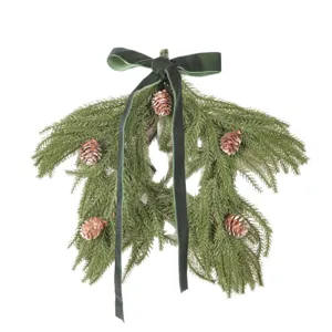 Christmas star pine branch wreath hanging with pinecones and velvet bow for holiday decor.
