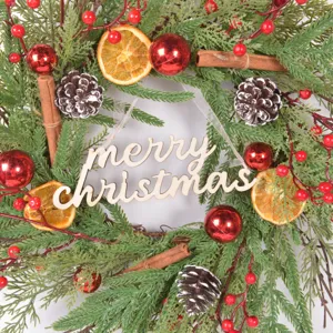Christmas wreath detail shot with pine needles, pinecones, dried orange slices and berries.